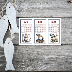 May include: Three printable bingo cards with a nautical theme. Each card has a different price: $20, $40, and $60. The cards feature a cartoon gnome wearing a blue and white striped hat and holding a telescope. The gnome is standing in front of a lighthouse.