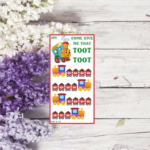 Puede incluir: Un tren de dibujos animados rojo, amarillo y azul con una cara sonriente. El tren está sobre un fondo rojo con el texto "Come give me that Toot Toot" y "56 €". Hay trenes más pequeños debajo con números en ellos.