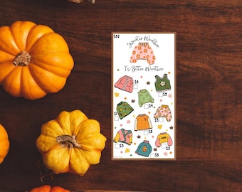 Op de afbeelding: Een printbare checklist met een herfstthema. Het bevat een verscheidenheid aan truien met verschillende patronen en kleuren. De tekst luidt "Sweater Weather Is Better Weather".