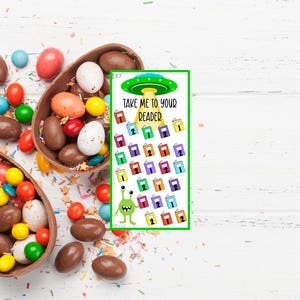 May include: A green alien with large eyes and a book in its hand. The alien is on a bookmark with the text "Take me to your reader" and a pattern of colorful books with numbers 1 and 2 on them.