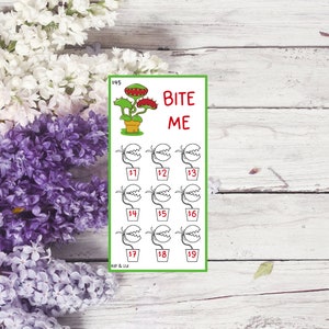 May include: A green and white card with the text "BITE ME" and a cartoon image of a Venus flytrap plant. The card has nine squares with numbers 1 through 9, each with a cartoon image of a Venus flytrap plant.