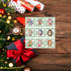 May include: A square grid of nine Christmas-themed animal illustrations on a wooden surface. Each square features a different animal, including a cat, deer, and hedgehog, all wearing festive attire. The scene is decorated with wrapping paper, a gift box, and Christmas tree branches.