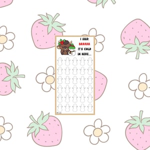 May include: A rectangular card with a winter theme, featuring a cartoon bull and snowman with the text "I said brrrrr it's cold in here...." The card is surrounded by a pattern of pink strawberries and white flowers.