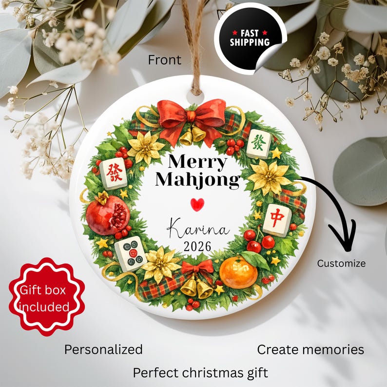 Pu&ograve; includere: Ornamento natalizio in ceramica bianca con un design Mahjong festivo. L'ornamento presenta una ghirlanda con fiocchi rossi, campane dorate e tessere di Mahjong. Il testo "Merry Mahjong" e un nome sono visualizzati.