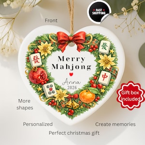 Pu&ograve; includere: Ornamento natalizio a forma di cuore con un design Mahjong festivo. L'ornamento presenta un fiocco rosso, accenti floreali e il testo "Merry Mahjong" con un nome e un anno. Scatola regalo inclusa.