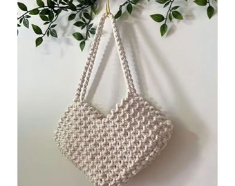May include: A white heart-shaped crocheted tote bag with two straps.