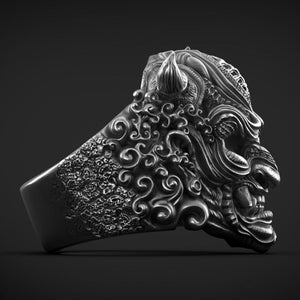 May include: A silver ring with a detailed design of a Japanese demon's face. The ring features intricate carvings of clouds and other decorative elements.