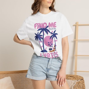May include: White t-shirt with a graphic design featuring palm trees, a pink sun, and the text "FIND ME DECODING LYRICS" in pink and blue. The design includes a person listening to music on a beach. The shirt is worn with denim shorts.