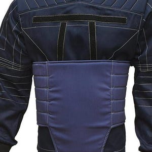 May include: Navy blue jacket with a high collar and white stitching details. The jacket features a padded chest panel and black accents. The design includes a structured silhouette, suitable for various activities.