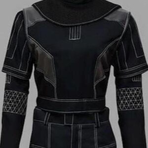 Peut inclure: Costume noir avec des coutures blanches. La tenue comprend un col montant, des empi&egrave;cements aux &eacute;paules et des motifs g&eacute;om&eacute;triques sur les manches. La conception comprend une ceinture et un pantalon ajust&eacute;, cr&eacute;ant un look futuriste.