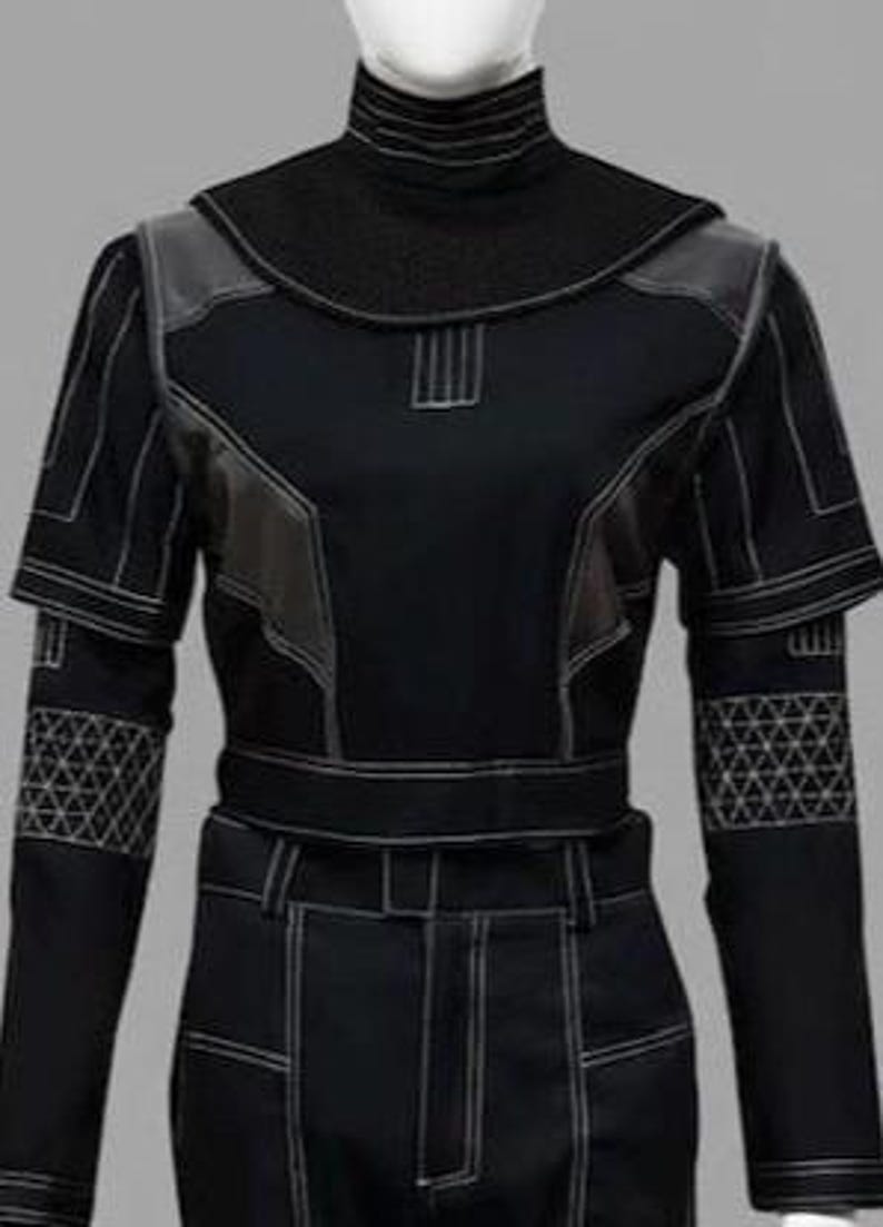 Peut inclure: Costume noir avec des coutures blanches. La tenue comprend un col montant, des empi&egrave;cements aux &eacute;paules et des motifs g&eacute;om&eacute;triques sur les manches. La conception comprend une ceinture et un pantalon ajust&eacute;, cr&eacute;ant un look futuriste.