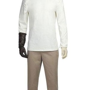 May include: A mannequin displays a costume. The outfit includes a white long-sleeve shirt with a mandarin collar, tan pants, and a black glove on the left hand. The costume is designed for a theatrical performance or cosplay.