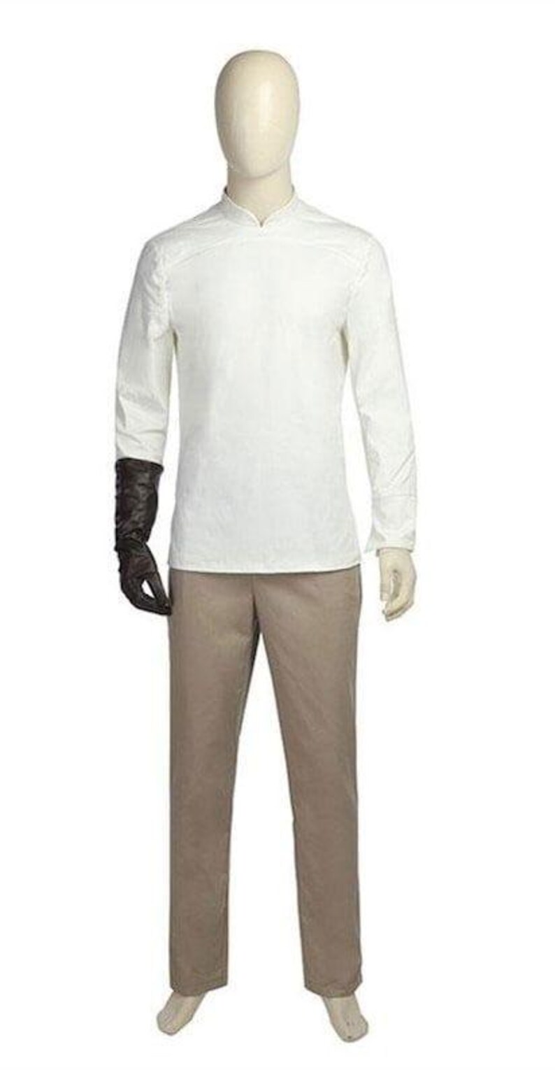 May include: A mannequin displays a costume. The outfit includes a white long-sleeve shirt with a mandarin collar, tan pants, and a black glove on the left hand. The costume is designed for a theatrical performance or cosplay.
