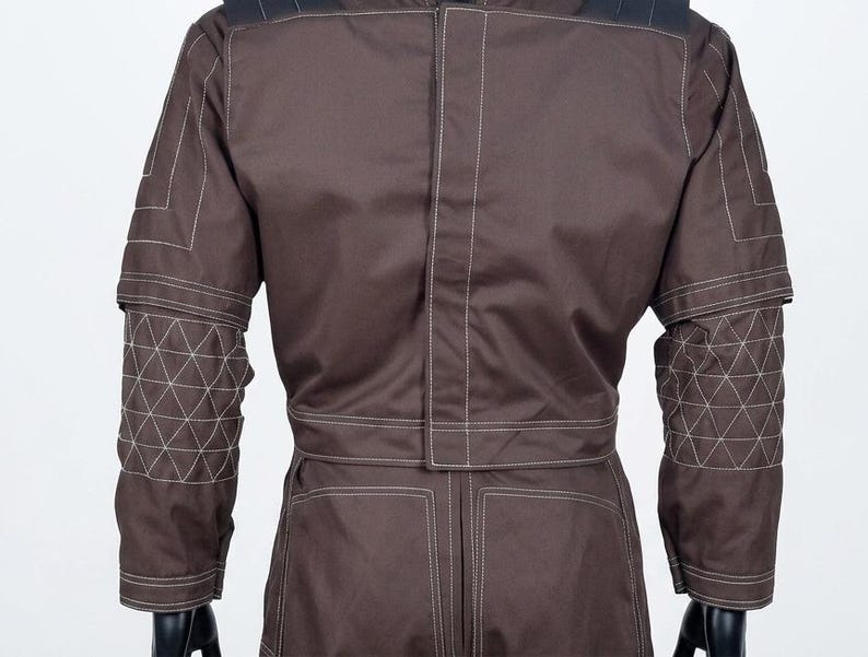May include: A brown jacket with white stitching. The sleeves have geometric patterns, and the design is structured. The back view highlights the tailored fit and contrasting stitching details.