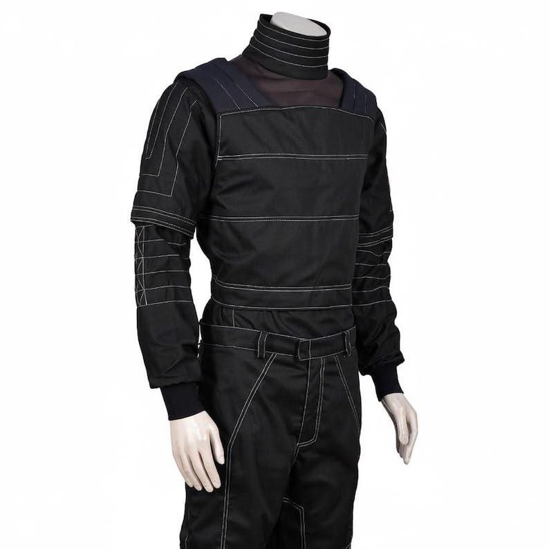 May include: A black long-sleeved top and matching pants set featuring a high mock neck collar. The garment is detailed with prominent white topstitching that creates horizontal lines across the chest, sleeves, and legs, with reinforced shoulder panels.