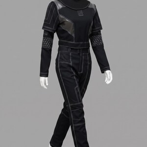 Peut inclure: Combinaison noire avec des coutures blanches. La tenue comprend un haut &agrave; col montant avec des d&eacute;tails en cuir et des manches longues. Le pantalon est droit. Le mannequin est sur fond gris.