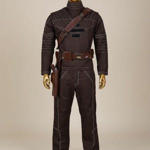 May include: A dark brown long-sleeved shirt and matching trousers set featuring white contrast stitching, a high collar, and a brown leather-like utility belt with a holster. The outfit includes a diagonal shoulder strap and black rectangular patches.