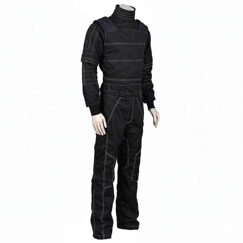 May include: A black long-sleeved jumpsuit featuring a high mock neck collar and prominent white contrast stitching throughout the garment. The design includes structured shoulder panels, fitted cuffs, and reinforced seams on the legs and torso.