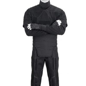 May include: Black tactical jumpsuit with a high collar, quilted detailing, and white stitching. The outfit includes matching gloves and pants. The mannequin is wearing the full outfit.