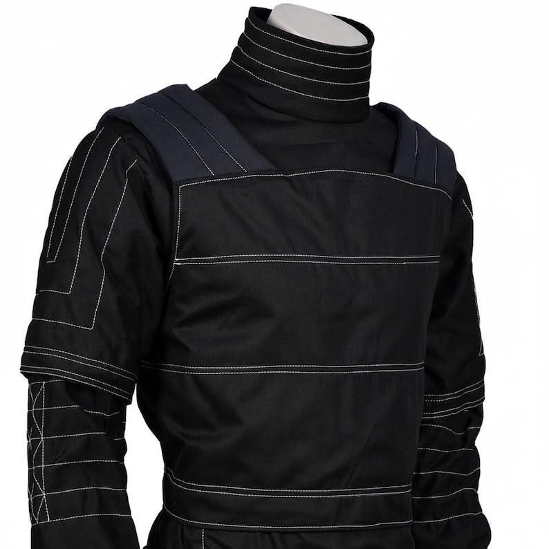 May include: A black long-sleeve shirt featuring a high turtleneck collar and structured shoulder panels. The garment is detailed with prominent white topstitching that creates horizontal lines across the chest, sleeves, and collar area.