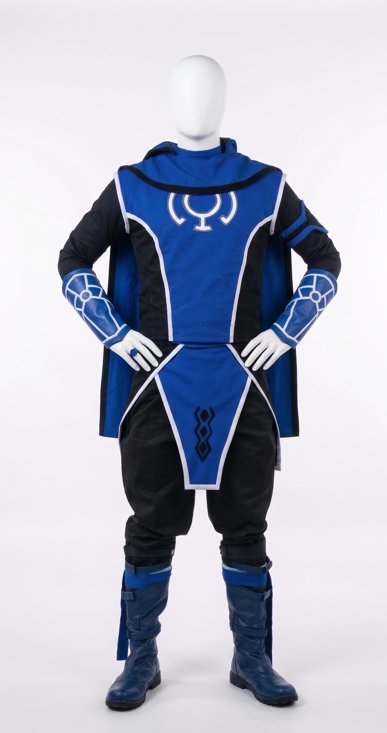 May include: A blue and black costume featuring a hooded tunic with a white circular emblem on the chest, matching arm guards with white geometric patterns, a long cape, black trousers, and blue boots with straps, displayed on a white mannequin.