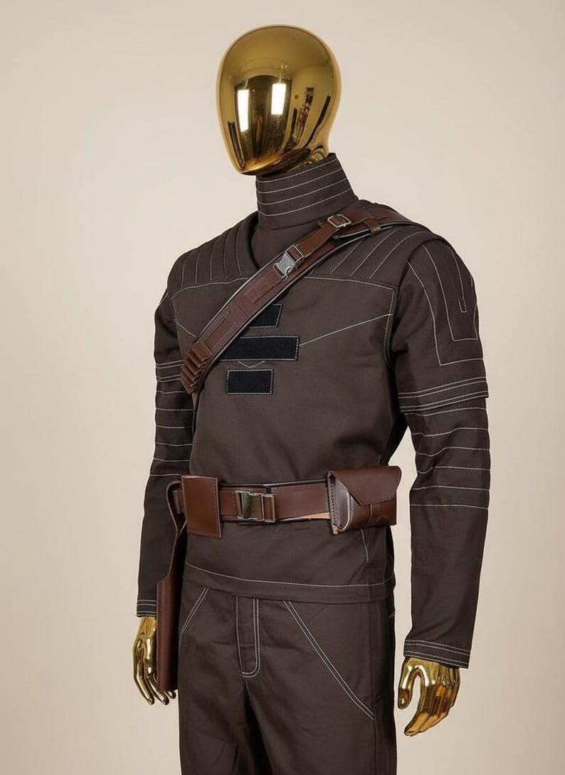 May include: A dark brown long-sleeved tactical outfit featuring a high collar, white topstitching, and a brown utility belt with pouches. A brown shoulder strap with a buckle crosses the chest, which displays three horizontal black rectangular patches.