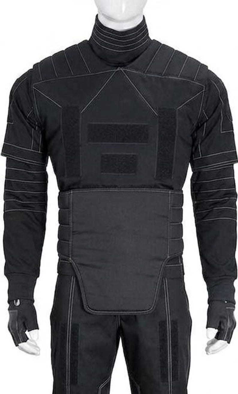 May include: Black tactical uniform with white stitching details. The outfit includes a high-collared jacket, pants, and fingerless gloves. The jacket features reinforced panels and multiple Velcro closures. The overall design suggests a focus on protection and functionality.