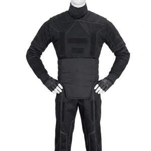 May include: A black tactical suit displayed on a mannequin. The suit includes a high-collared jacket with reinforced panels, matching pants, and gloves. White stitching accents the seams and panels. The overall design suggests a focus on protection and functionality.