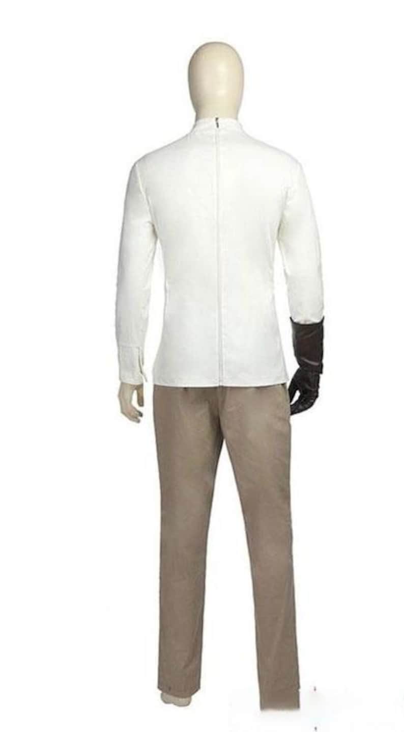 May include: A mannequin wearing a white long-sleeved jacket with a zipper down the back, paired with tan pants. The mannequin has a black glove on its right hand. The outfit is displayed against a white background.