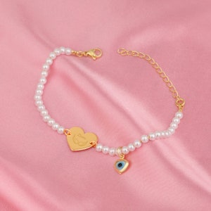 a bracelet with a heart and a evil eye