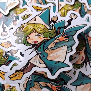 May include: A sticker featuring a cartoon character with green hair, wearing a teal and white hat and cape. The character is smiling and has their arms outstretched. The sticker has a white border and is surrounded by other similar stickers.