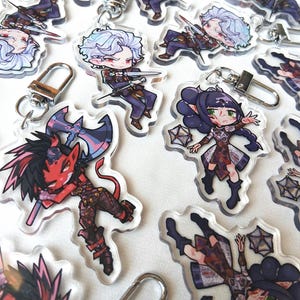 Könnte beinhalten: Eine Sammlung von Acryl-Schlüsselanhängern mit Charakteren im Anime-Stil. Die Schlüsselanhänger zeigen verschiedene Charaktere in Action-Posen, mit leuchtenden Farben und detaillierten Designs. Jeder Schlüsselanhänger hat einen silbernen Verschluss zur einfachen Befestigung.