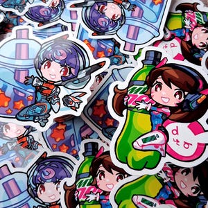 May include: A collection of colorful stickers featuring anime-style characters. The stickers showcase a character in a spacesuit and another holding a green bottle. The stickers have a white border and are scattered across the image.