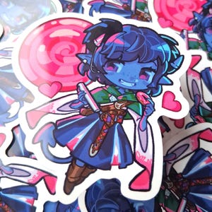 Könnte beinhalten: Aufkleber mit einem blauhäutigen Charakter mit dunkelblauen Haaren, der einen rosa Lutscher und eine Schriftrolle hält. Der Charakter trägt ein blaues und grünes Outfit mit braunen Stiefeln. Rosa Herzen und ein rosa-roter Lutscher sind ebenfalls zu sehen.