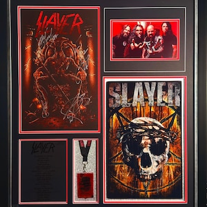 Puede incluir: Obra de arte enmarcada con recuerdos de la banda Slayer. Incluye un póster firmado con un esquema de color rojo y marrón, una foto de la banda y un póster con un diseño de calavera y corona de espinas. También incluye un cordón y una tarjeta pequeña.