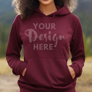 Op de afbeelding: Een maroon hoodie met een grote zak aan de voorkant. De tekst "YOUR Design HERE" is op de voorkant van de hoodie gedrukt.