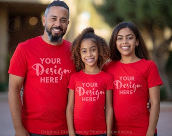 May include: A family of three wearing red t-shirts with the text "Your Design Here" printed on them. The father is standing in the center, with his daughter on his left and his daughter on his right.