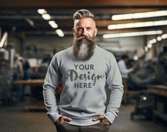 May include: A grey sweatshirt with the text "YOUR Design HERE" printed on the front. The sweatshirt is being worn by a person with a long grey beard in a workshop setting.