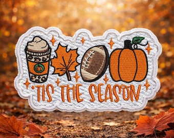 May include: Embroidered patch with a coffee cup, maple leaf, American football, and pumpkin. The white patch has orange and brown details, and the text "'Tis the Season" in orange. It is surrounded by orange star accents.