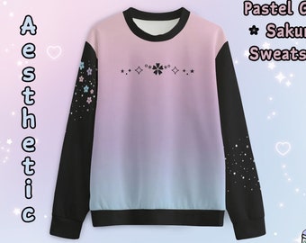 May include: Pastel pink and blue gradient sweatshirt with black sleeves. The sleeves have a white floral pattern on one side and a white star pattern on the other. The front of the sweatshirt has a white flower graphic and the text "Pastel Goth * Sakura * Sweatshirt".