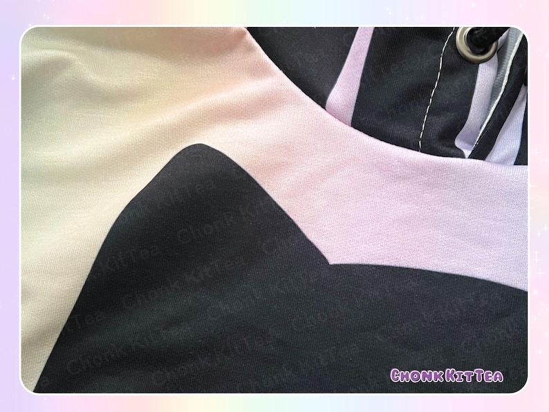 May include: Close-up of a black, white, and light pink hoodie. The design features a large black shape on the front, with a light pink band around the hood. The text "Chonk KitTea" is visible in the lower right corner.