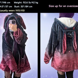 May include: A black and red ombre hoodie with bunny ears attached to the hood. The hoodie has a zipper closure and two pockets. The text "Size up for an oversized look!" is visible in the image.