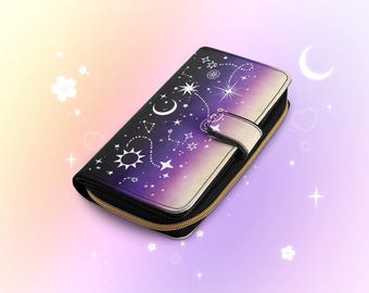 以下が含まれることがあります： 星、月、太陽が描かれた、黒と紫の財布。 金色のジッパーとスナップ留めが付いています。 デザインは黒から紫、白へと変化します。