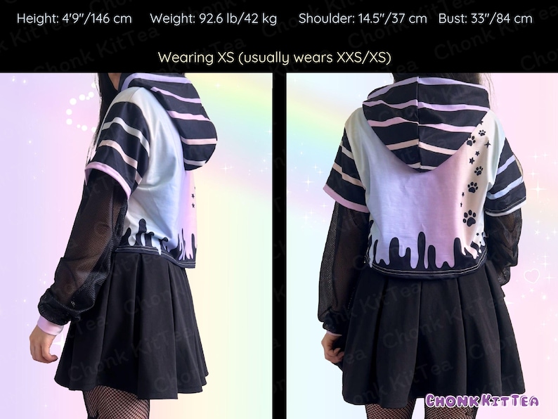 May include: A two-piece outfit featuring a black pleated skirt and a cropped hoodie. The hoodie has a white, blue, and pink color scheme with black stripes and dripping paint details. The outfit is designed with a unique aesthetic.