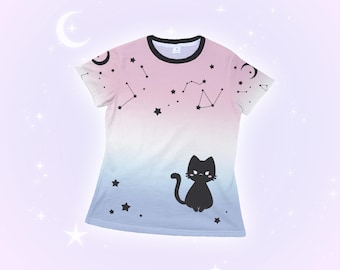 May include: A short-sleeved t-shirt with a pink to blue gradient. It features a black cat illustration, constellations, stars, and crescent moons. The neckline is black. The design is a celestial theme.