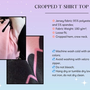May include: Pink cropped t-shirt with black graphic print. The shirt is made of a jersey fabric blend of 95% polyester and 5% spandex. The fabric weight is 180 g/m&sup2;. The shirt has a loose fit, cropped hem, and crew neck.