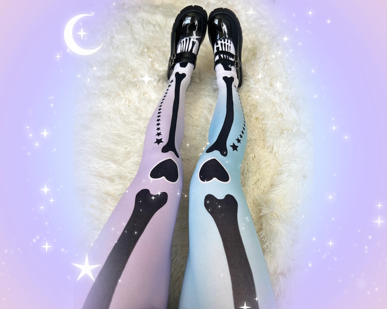 May include: Opaque tights featuring a gradient skeleton bone print in black against a pastel lavender and light blue background. The design includes heart-shaped knee joints and a row of small stars along the outer leg. Black patent leather shoes.