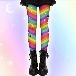 May include: Leggings with a rainbow stripe design and black star patterns, paired with black lace-up boots. The leggings' rainbow pattern is made up of diagonal stripes. The boots have thick soles and laces, creating a striking, colourful look.