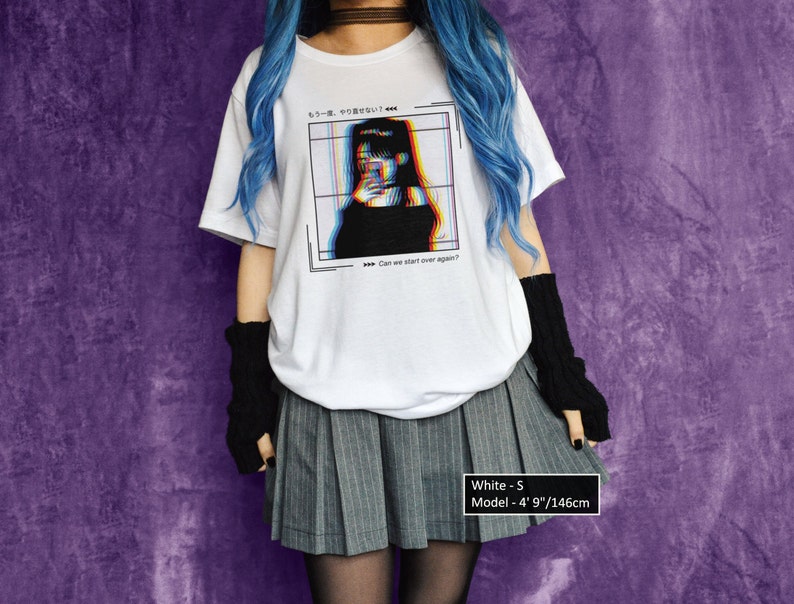 K&ouml;nnte beinhalten: Wei&szlig;es T-Shirt mit einem Grafikdruck eines Frauen Gesichts mit Glitch-Effekt. Der Text auf dem Shirt lautet "もう一度、やりせない" und "Can we start over again?" Das Model tr&auml;gt ein wei&szlig;es T-Shirt, einen grauen Faltenrock und schwarze fingerlose Handschuhe. Das Model ist 146 cm gro&szlig;.