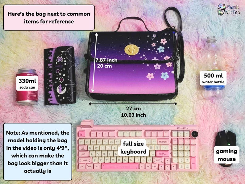 May include: A purple and black shoulder bag with a floral print and a gold clasp. The bag is next to a 330 ml soda can, a wallet, a full-size keyboard, a gaming mouse, and a 500 ml water bottle. The bag measures 7.87 inches tall and 10.63 inches wide.